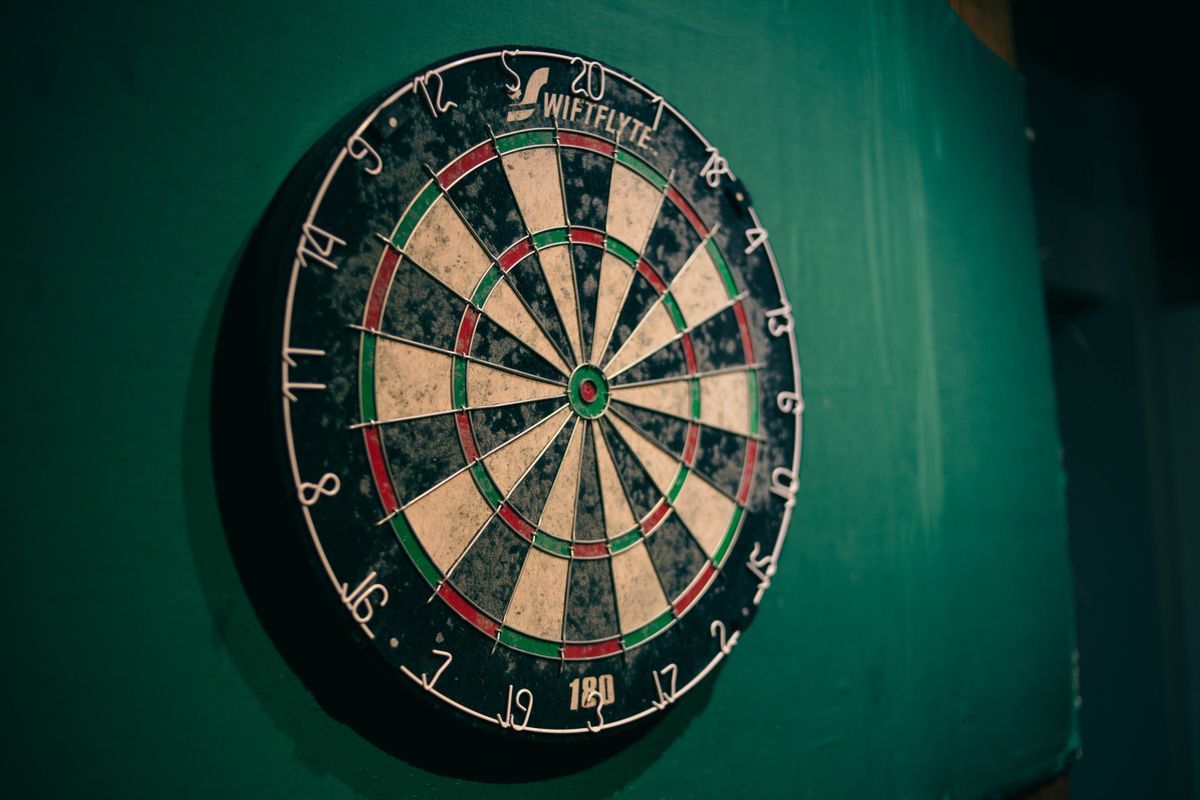 Klassisches Sisal-Dartboard an einer grünen Pub-Wand
