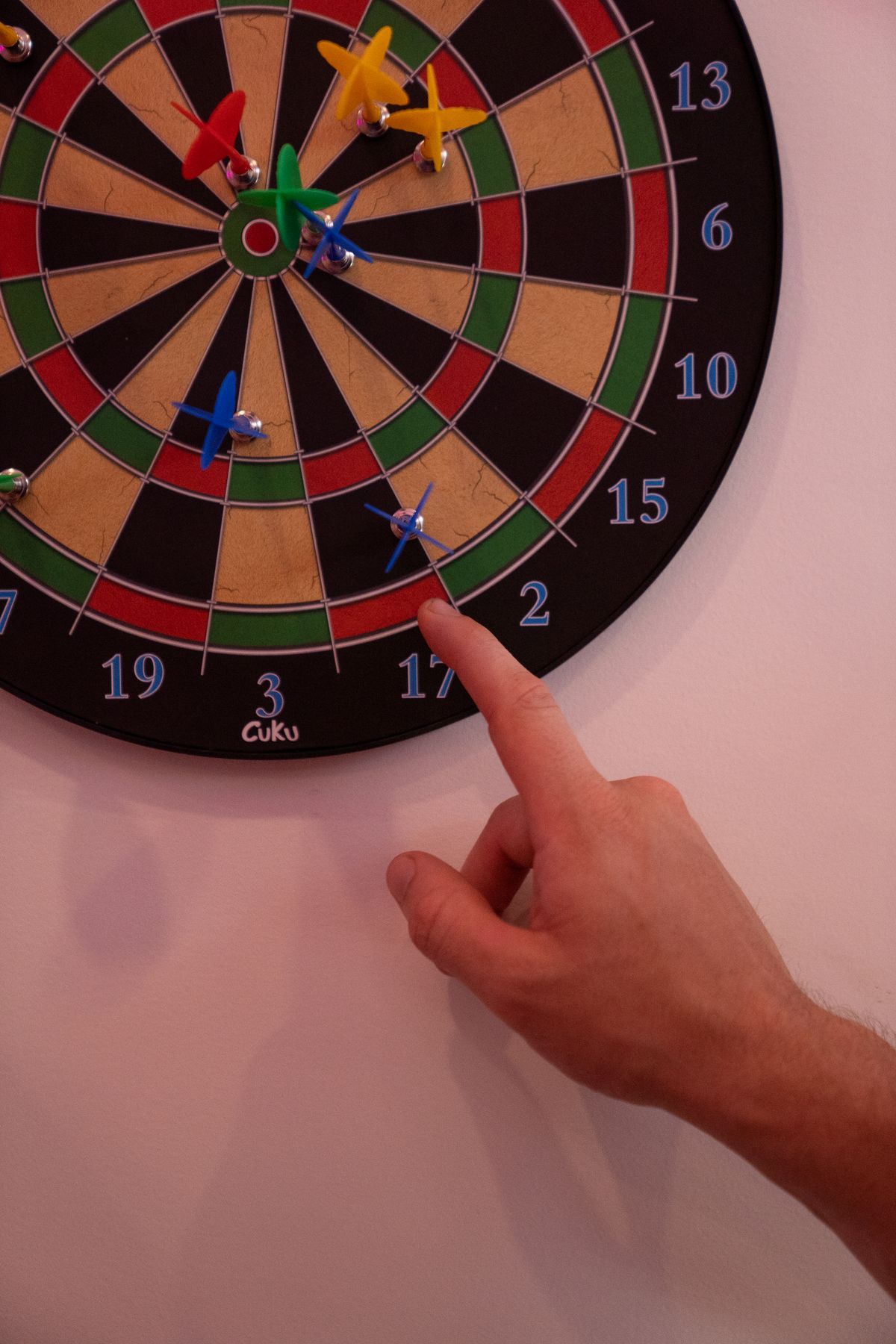 Hand an einer Dartscheibe mit Pfeilen