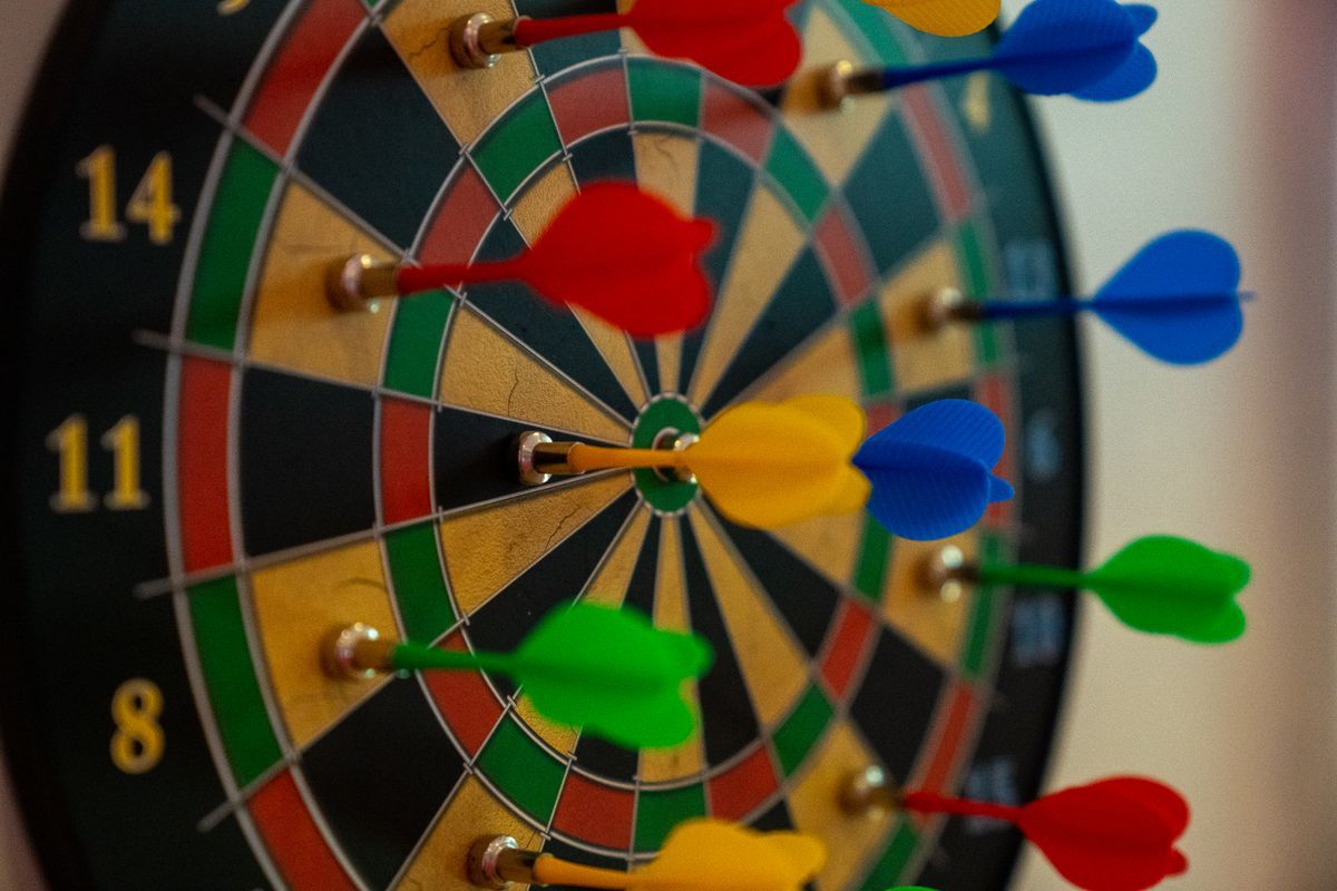 Bunte Softdartpfeile auf einer Dartscheibe