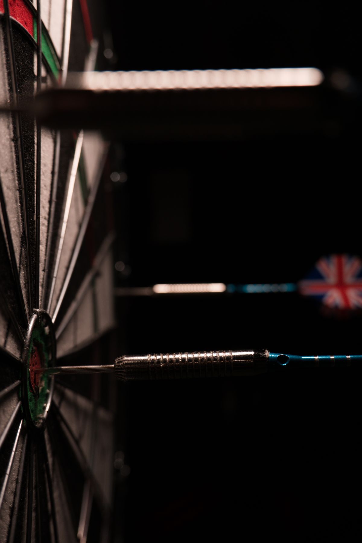 Steel-Dartspitzen im Bullseye vor schwarzem Hintergrund