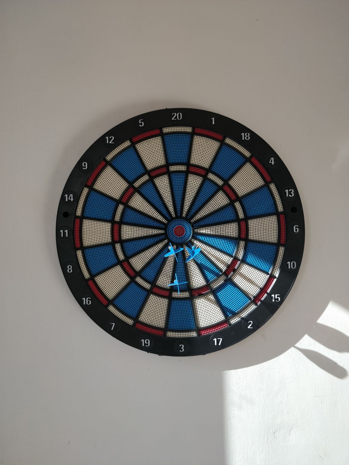 An der Wand montierte Dartscheibe mit Pfeilen