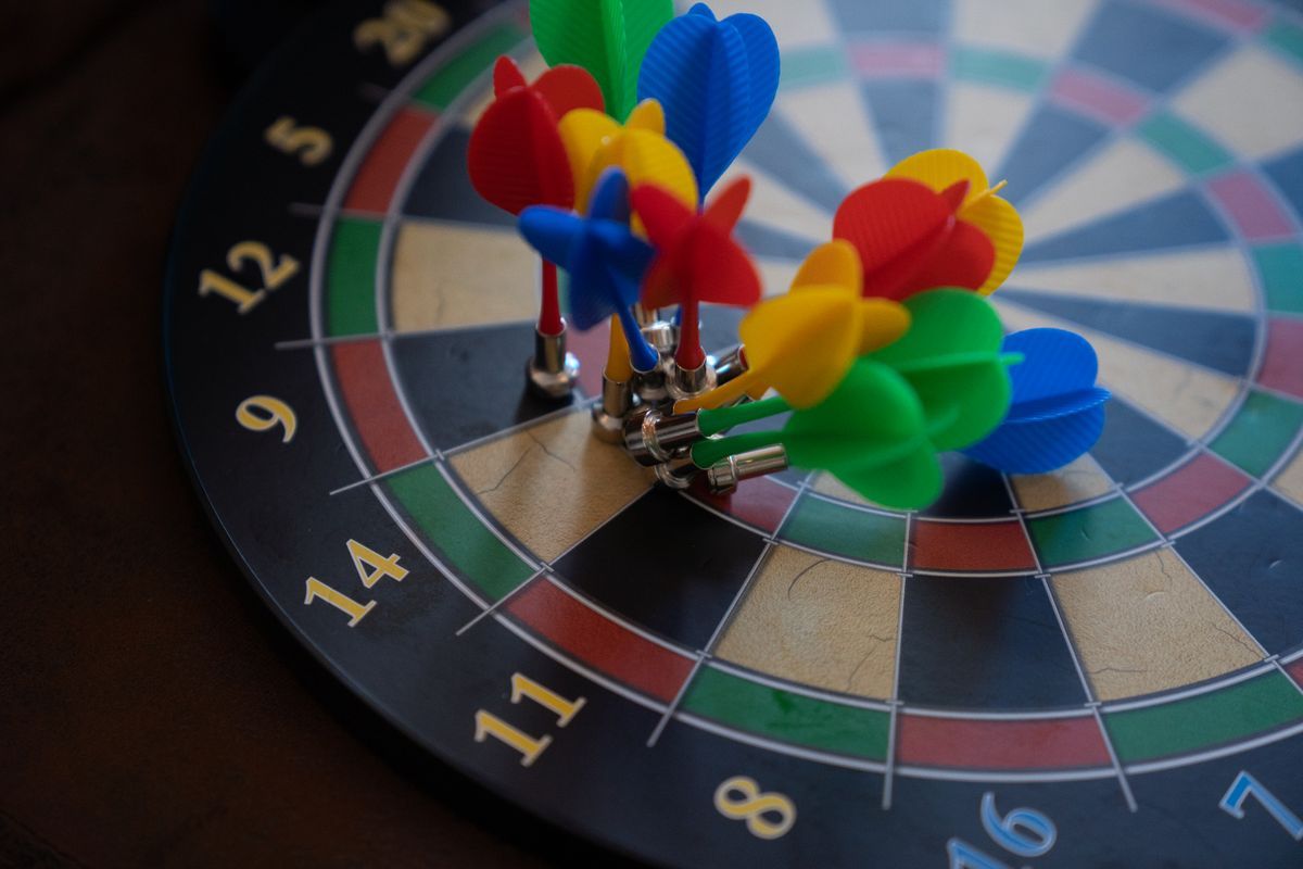 Bunte Magnet-Darts auf einer Dartscheibe